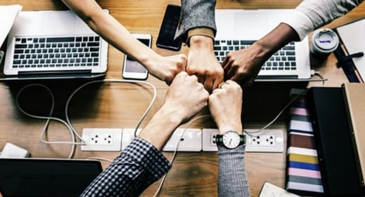 Fists over a computer to demonstrate strength against cyber security.