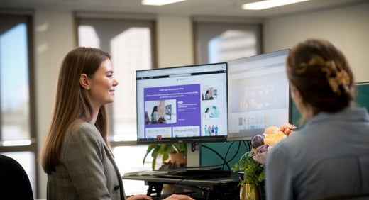 Person at a computer looking at images with a colleague Small City business pic]