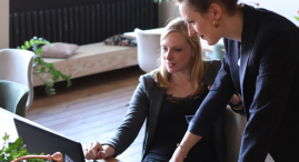 Two women sitting around a computer. Small